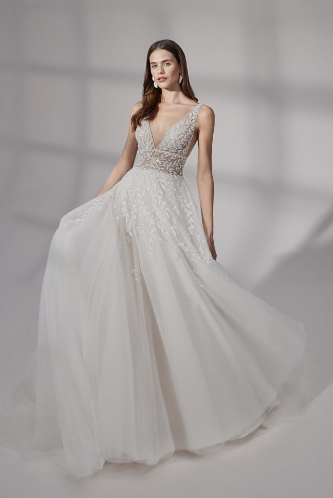 Deep v-neck ball gown with illusion bodice. This dress is glamorous, with a sand color from Justin Alexander.