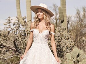 Lucille boho chic wedding dress by Lillian West worn by a bride in a large hat