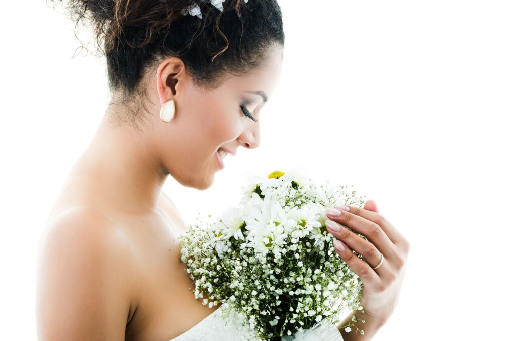 Bride looking lovingly at a bouquet of white flowers